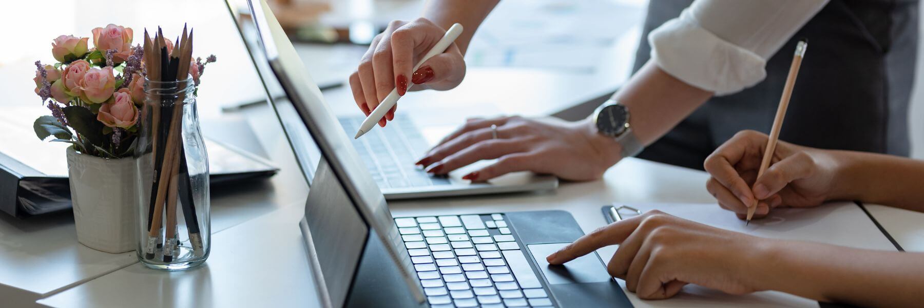 two people collaborating on digital documents on their laptops