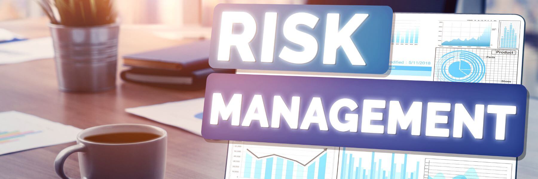 Risk Management overlayed on laptop screen showing charts