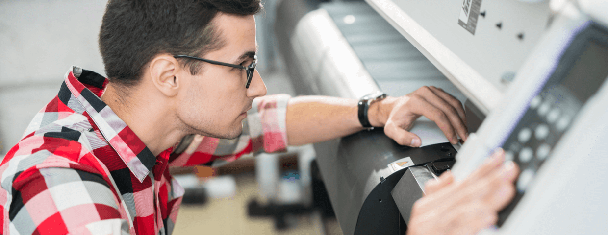 Man using wide format printer.