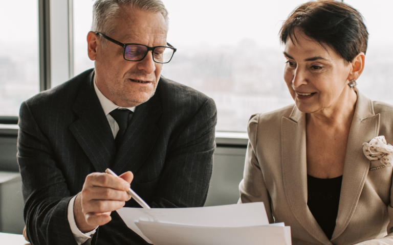man in suit showing documents to woman