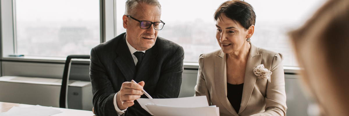 man in suit showing documents to woman