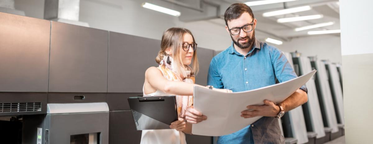 Woman and man talking in front of commercial printer