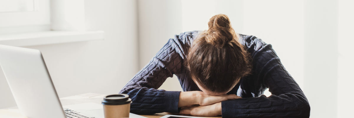 woman surrounded by tech with head on table