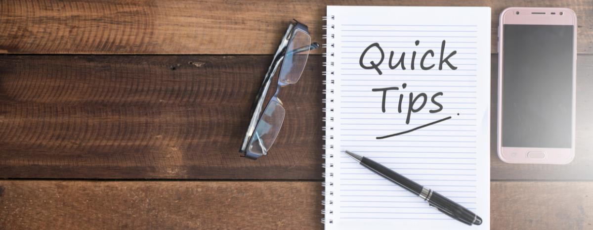 A pair of glasses and notepad on table, "quick tips" written on notepad.