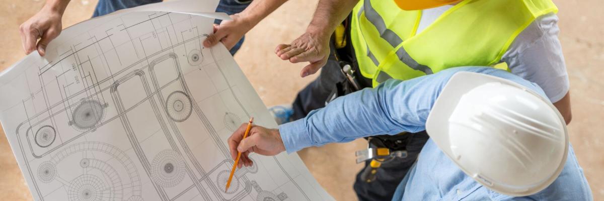 men in hardhats reviewing a blueprint